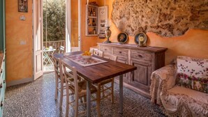 Una habitación acogedora con una mesa de comedor de madera, sillas, un sofá y una pared de piedra.