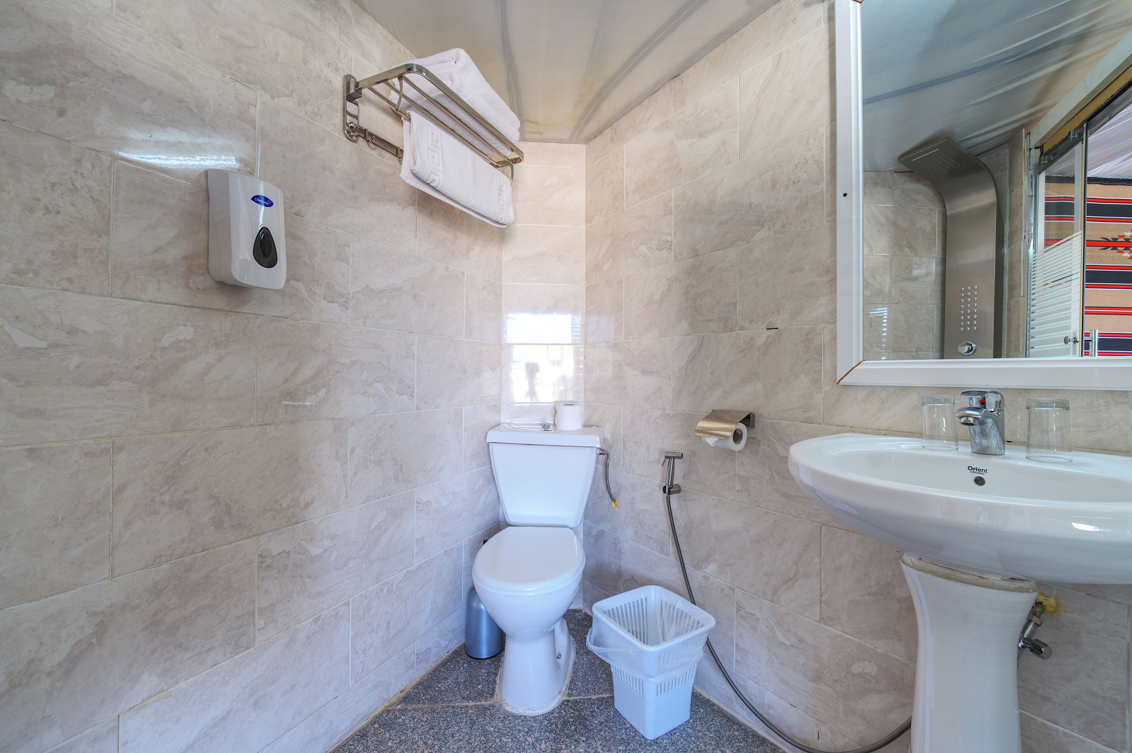 A small, modern bathroom with a toilet, sink, and hand dryer.