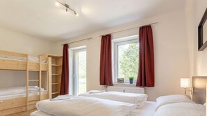 A room with bunk beds, a window with curtains, and a radiator. - mit 3 Schlafzimmern by Interhome (Eisenerz)