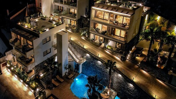 Hotel com vários andares, piscinas ao ar livre e terraços, com varandas e uma piscina central.