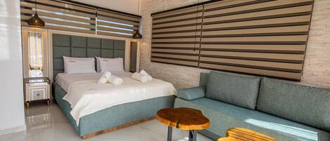 Een moderne slaapkamer met een groot bed, een bank en twee houten nachtkastjes.