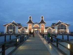 A waterfront building with a wooden deck leading to the entrance.