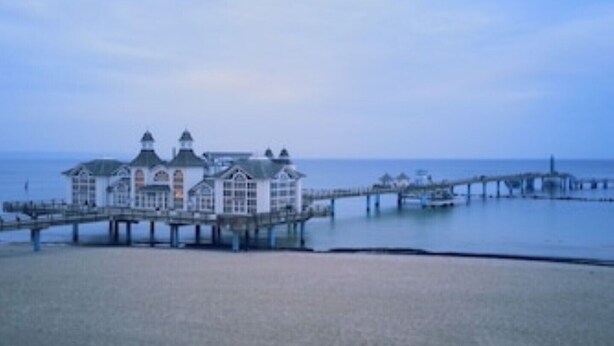 A coastal building with a pier extending into the water. - SELLIN-Wilhelmstraße, mod. apartment in top location, 200 m to the beach / pier, terrace (Sellin)