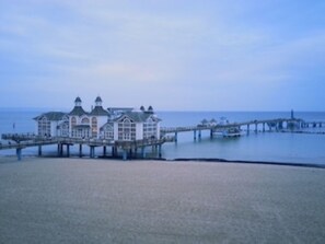 Un edificio costero con un muelle que se adentra en el agua.