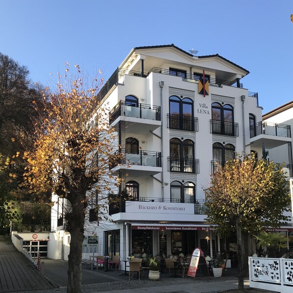 A multi-story building with balconies, a sign reading "Villa LENA," and outdoor seating with tables and chairs. - SELLIN-Wilhelmstraße, modern apartment in a prime location, 200 m from the beach/pier, terrace (Sellin)