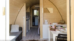A cozy, wooden interior with a dining area, a kitchen, and a living space.