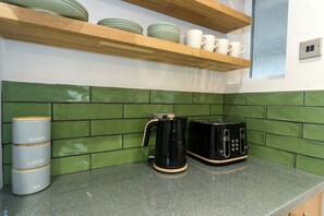 Kitchen area with a countertop, coffee maker, toaster, and storage for essentials.