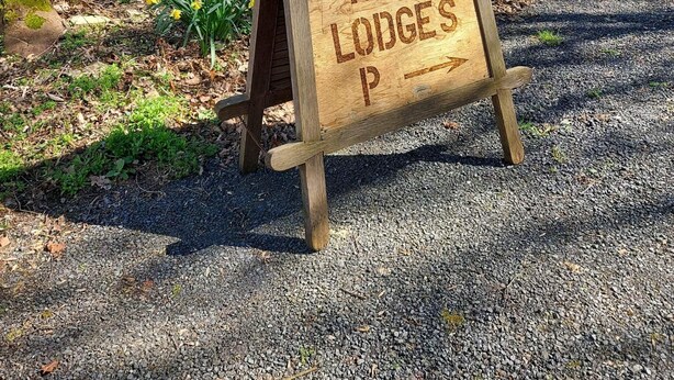 A wooden sign with the text "PARKS RISE LODGES P" indicating a direction to a park or lodge. - Sycamore Lodge-1 Bed-sleeps 4-free Parking (Hereford)