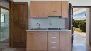 Una cucina moderna con mobili in legno, un lavello in acciaio inossidabile e un piano cottura a gas.