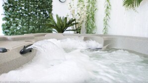 Ein Whirlpool mit fließendem Wasser, umgeben von viel Grün und einer Uhr an der Wand.