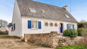 A two-story house with a stone wall in front, a sloped roof, and a chimney. - 800 m from harbour – House terrace BBQ – Sleeps 12 (Loctudy)