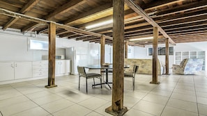 A spacious kitchen with white cabinets, a refrigerator, and a dining area with a table and chairs.