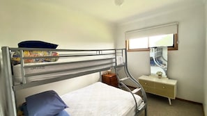 A bunk bed room with a bedside table and a mirror. - Minnie Water Beach House (Minnie Water)