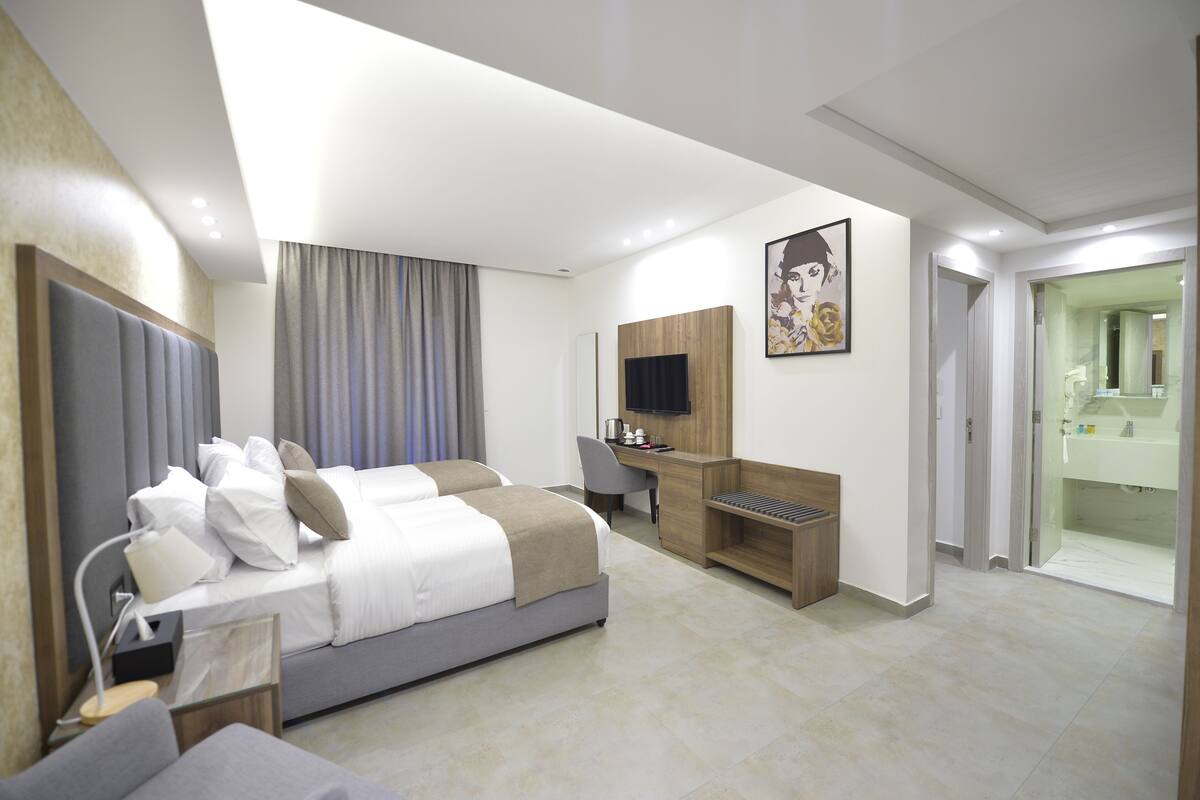 Una habitación de hotel moderna con cama, escritorio y televisión.