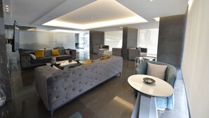 A modern living room with a grey sofa, a round coffee table, and a grey armchair. - ZETT HOTEL (Jounieh)