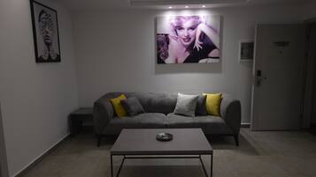 A modern room with a grey sofa, a coffee table, and a large framed picture on the wall.