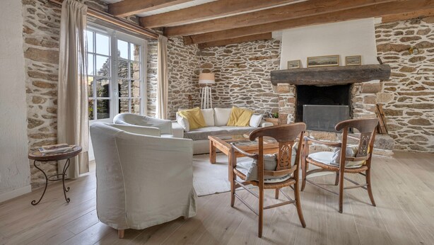 A cozy living room with stone walls, wooden beams, a fireplace, and comfortable seating. - Sarzeau – Stunning house for 10, garden & BBQ (Sarzeau)