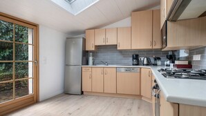 A modern kitchen with wooden cabinets, a stainless steel refrigerator, a dishwasher, and a gas stove. - Sarzeau – Stunning house for 10, garden & BBQ (Sarzeau)