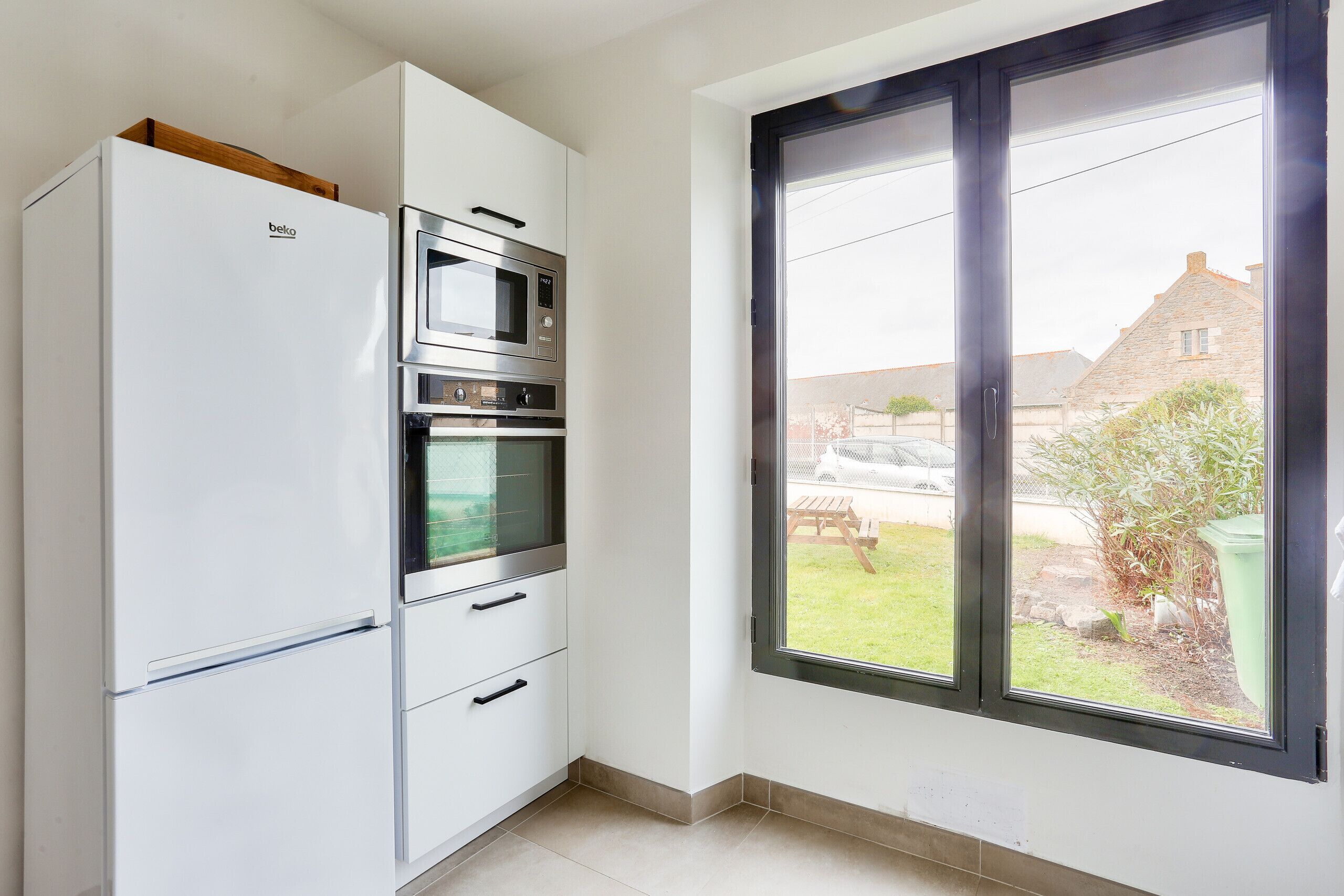 A kitchen with a built-in oven, microwave, and refrigerator.