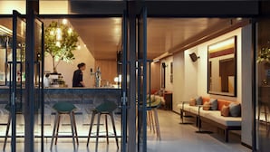 Un intérieur moderne avec un bar, des sièges et un grand miroir.