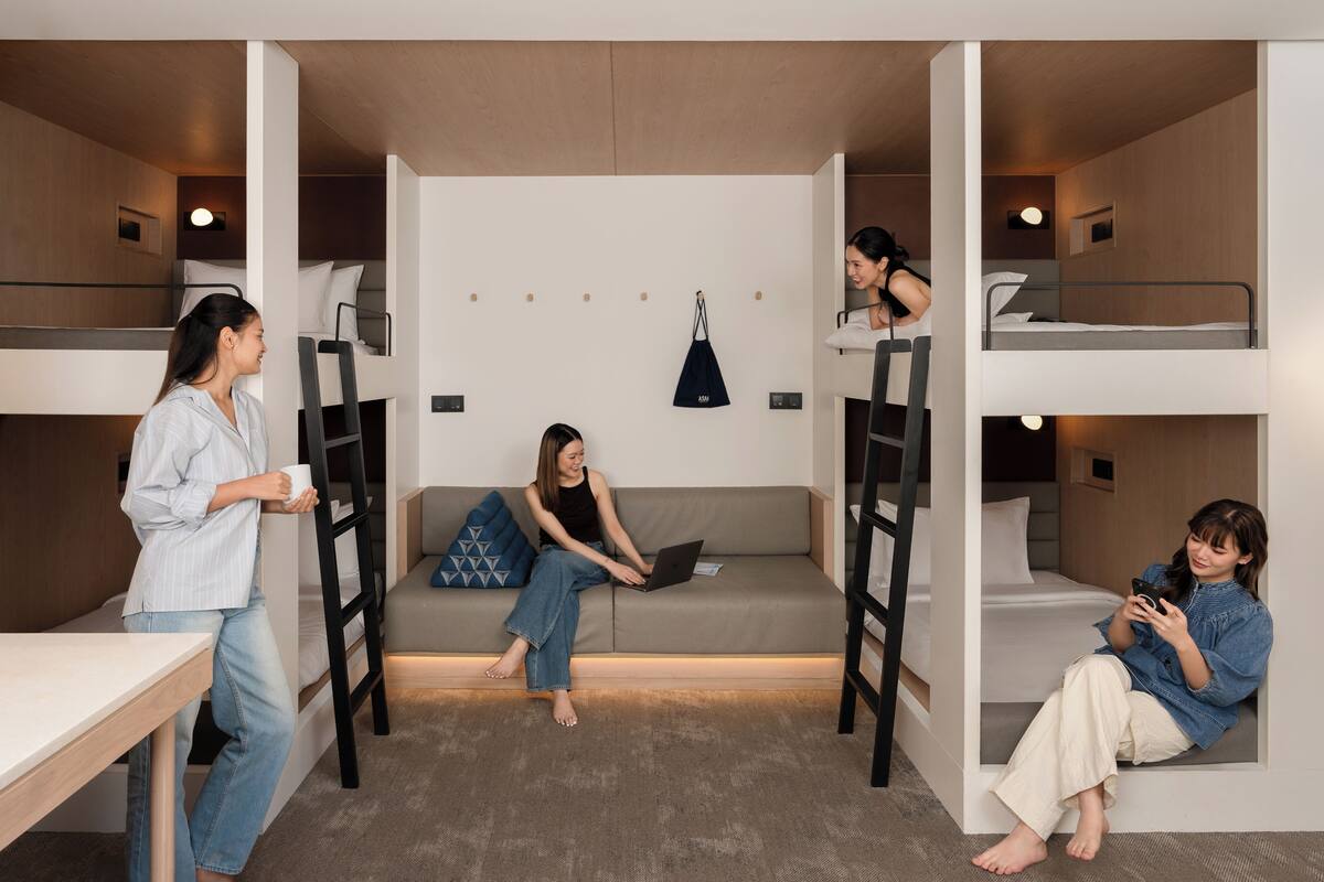 A modern, compact living space with bunk beds, a sofa, and a table.