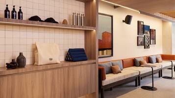 Una zona de recepción con un mostrador de madera, un sofá con cojines y una pared decorada con cuadros.