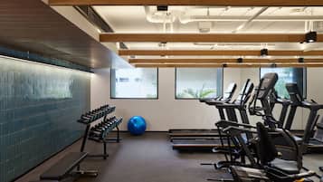 A gym with treadmills, elliptical machines, and free weights.