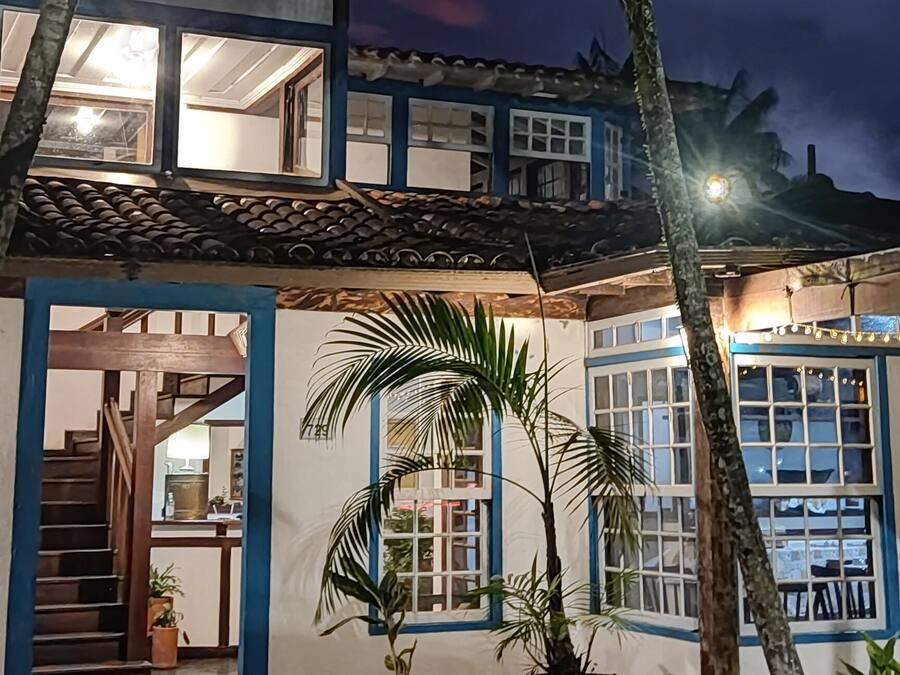 A two-story building with a tiled roof and blue-framed windows.