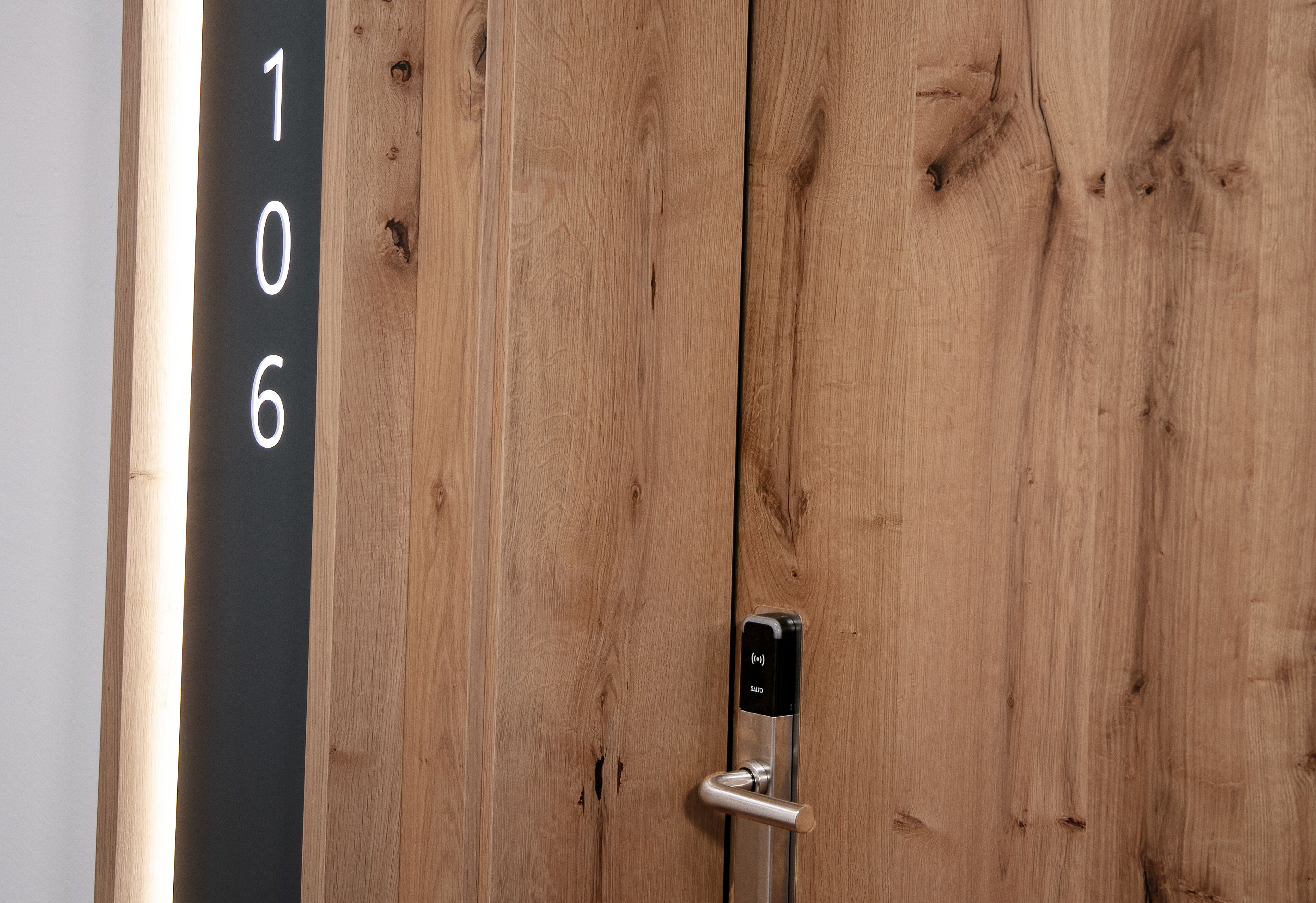 A wooden door with a numeric keypad lock and a door handle.