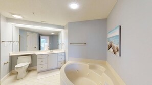 A bathroom with a toilet, sink, vanity, and bathtub. - One Bedroom with a Murphy Bed (Hilton Head)