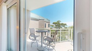 A balcony with a table and chairs, a railing, and a building in the background. - One Bedroom with a Murphy Bed (Hilton Head)
