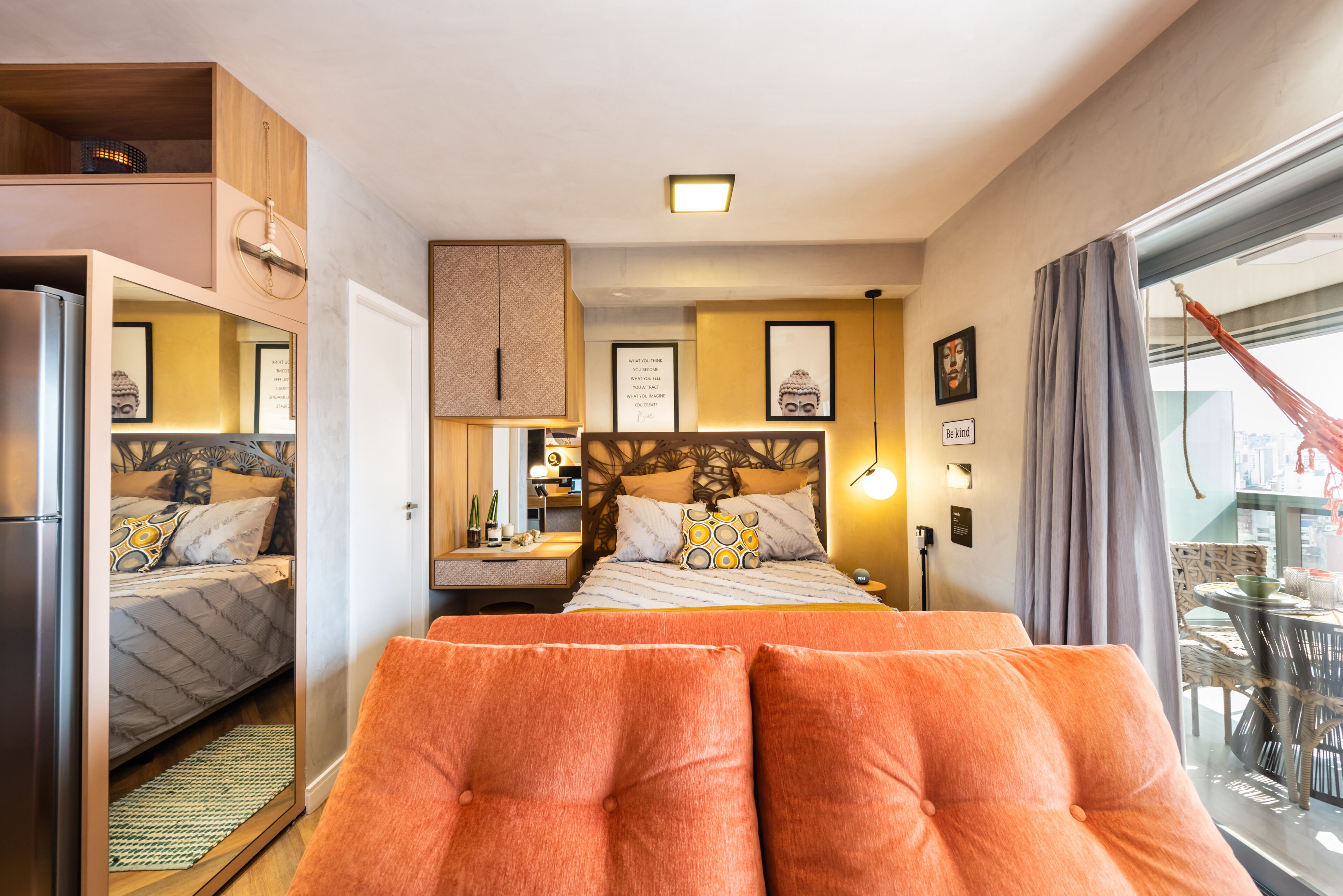 Une chambre d’hôtel avec un lit, un canapé, un bureau et une fenêtre avec des rideaux.