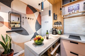 Cocina moderna con frutero, botella de vino, cafetera y un cartel que dice 'Bar Abierto'.