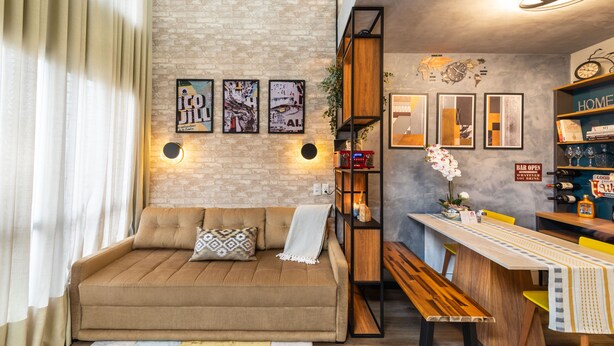 A cozy living area with a sofa, a wooden bench, a dining table with a bench, and a bookshelf. - Praca Benedito Calixto - Duplex (São Paulo)