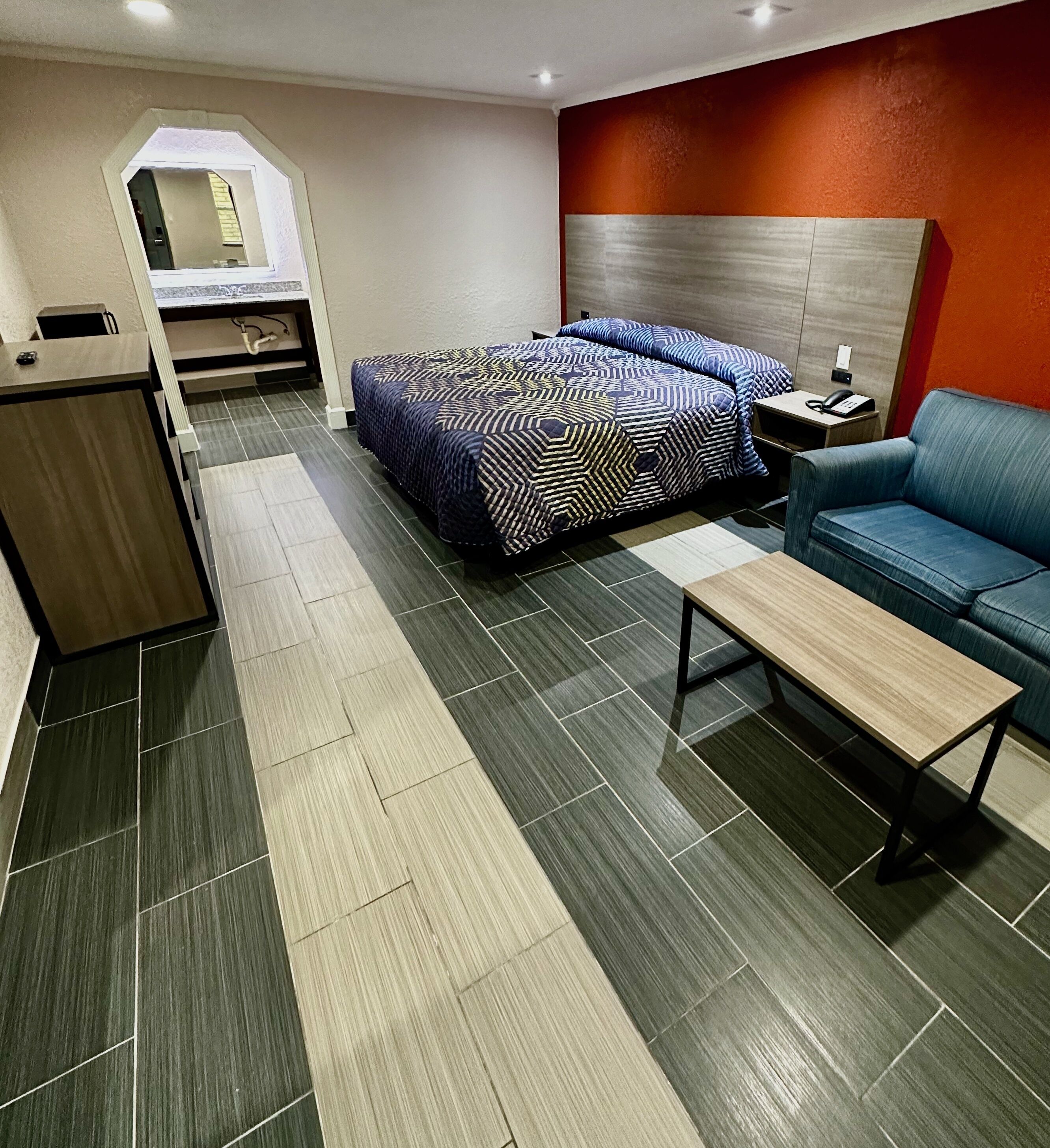Une chambre d’hôtel moderne équipée d’un lit, d’un bureau, d’une chaise et d’un canapé.