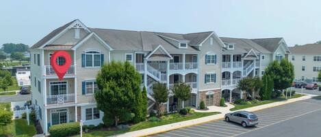 A multi-story hotel with a central courtyard, balconies, and a parking lot.