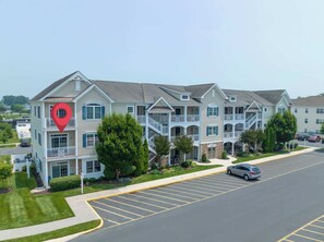 A multi-story hotel with a central courtyard, balconies, and a parking lot.