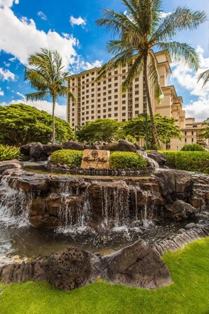 A hotel with a large building, a waterfall, and palm trees. - Hale Kahakai Ko Olina Beach Villa w/ Pool! (Kapolei)