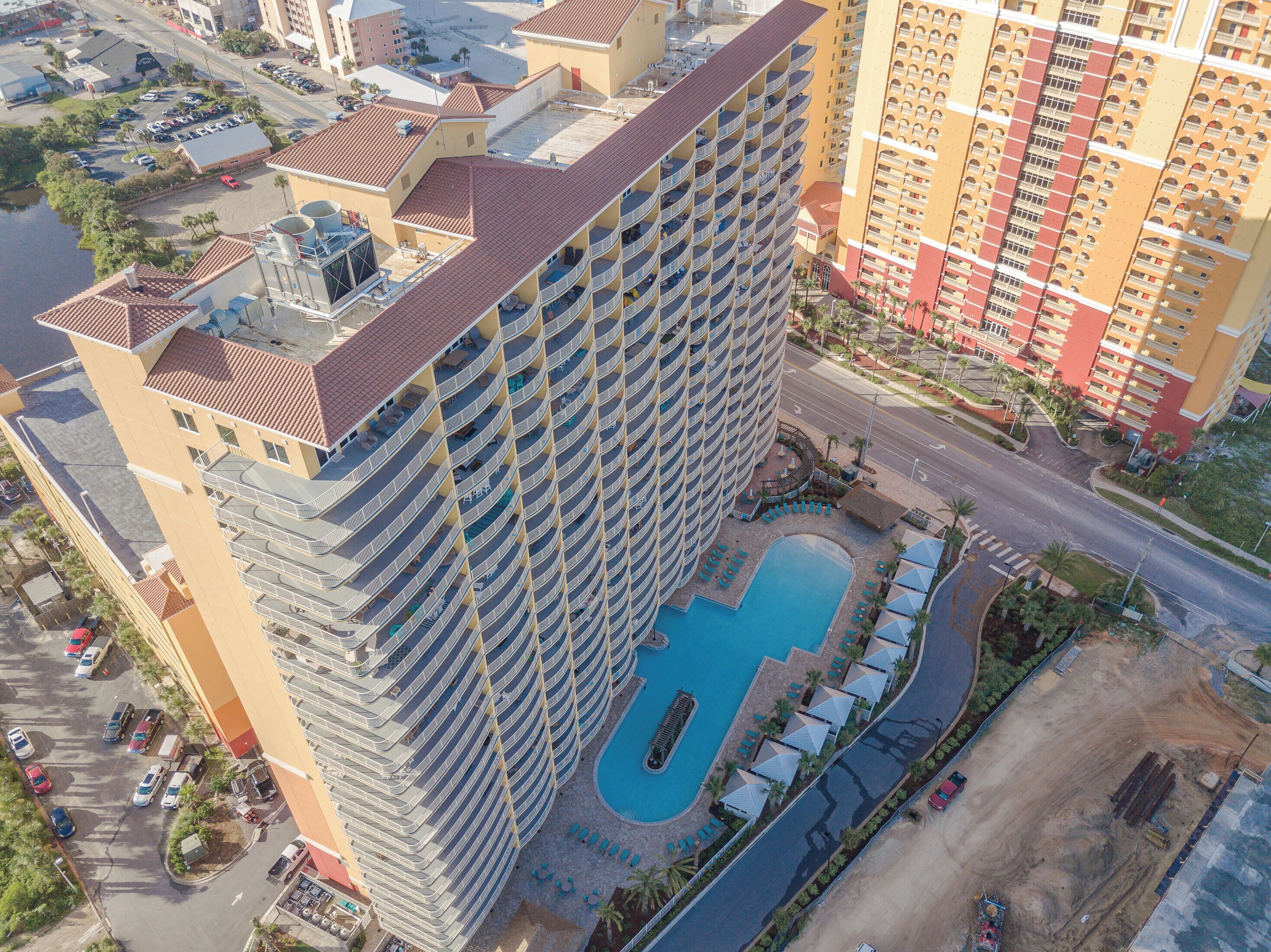 Un hôtel de grande hauteur doté d’une piscine sur le toit et de nombreux balcons.