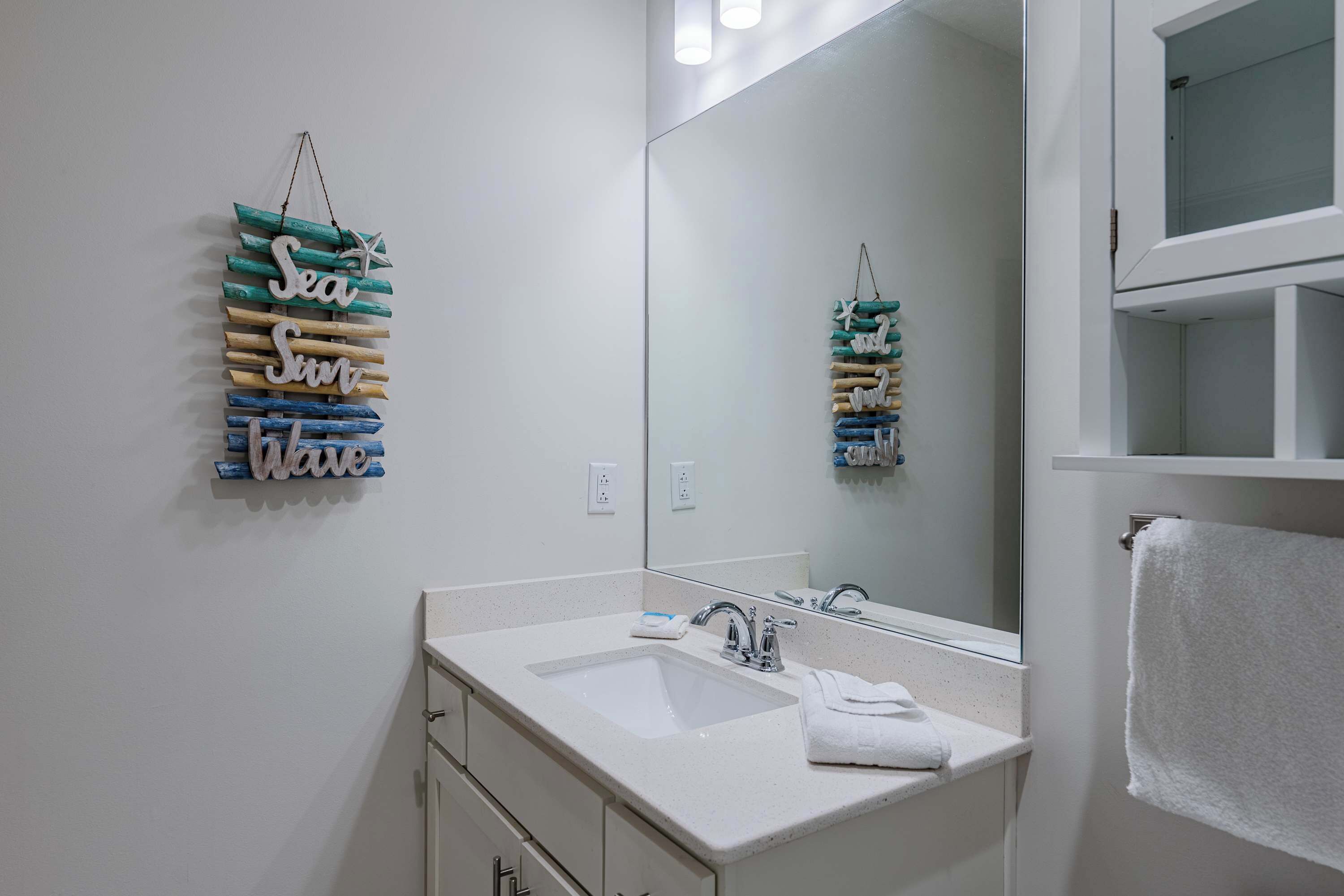 A bathroom with a white sink, mirror, and a towel rack.