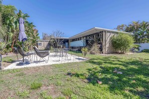 A modern house with a patio, outdoor furniture, and a large screen. - Mid Century Modern Weekly Winter Rates! (Tampa)