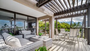 A covered outdoor seating area with wicker furniture, a table, and chairs. - Gorgeous Expansive Condo in Wailea with HUGE Lanai & Ocean Views (Kihei)