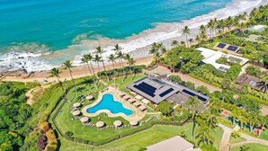 An aerial view of a resort with a swimming pool, beach access, and lush landscaping. - Gorgeous Expansive Condo in Wailea with HUGE Lanai & Ocean Views (Kihei)