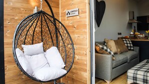 Una habitación con una silla colgante, un sofá y un letrero que indica 'LOWFIELD Leisure'.