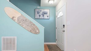 Una escalera con un monopatín, un cuadro de un mapa mundial y una puerta.