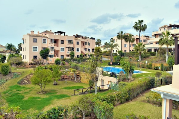 Een woonwijk met meerdere appartementencomplexen, een zwembad en verzorgde tuinen.