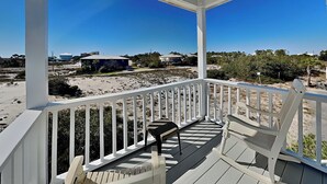 A covered porch with a view of the beach and houses in the distance. - Seahawk South C | Two Units In One, Community Pool + Steps to Beach (Fort Morgan)