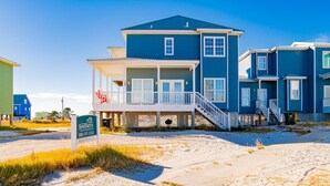 A beachfront house with a covered porch, a staircase, and a sign indicating Southern Vacation Rentals. - Seahawk South C | Two Units In One, Community Pool + Steps to Beach (Fort Morgan)