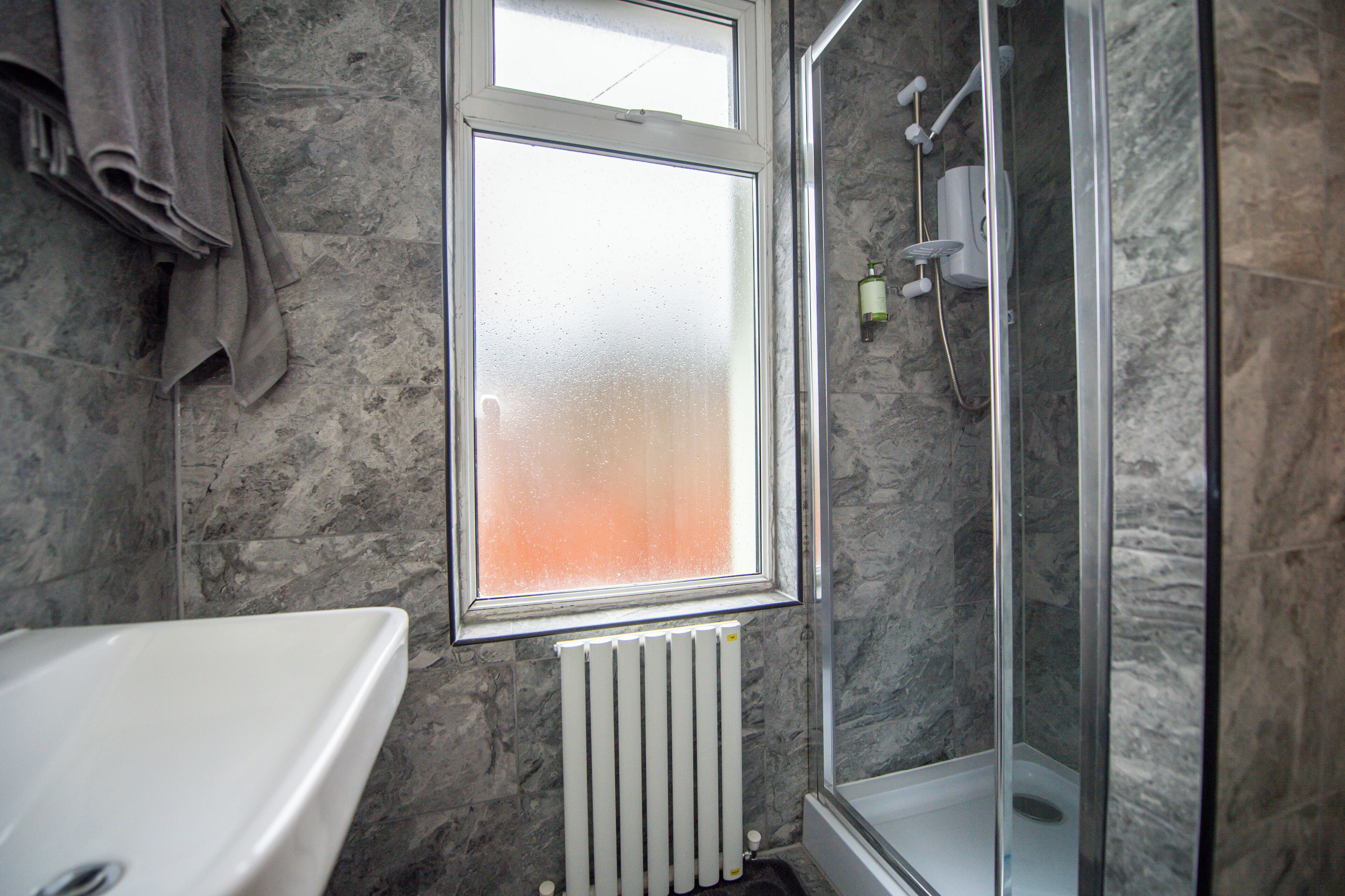 A bathroom with a bathtub, a shower, and a window.