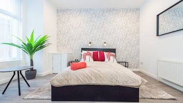 Een bureau, een laptopwerkplek, een strijkplank/strijkijzer, beddengoed